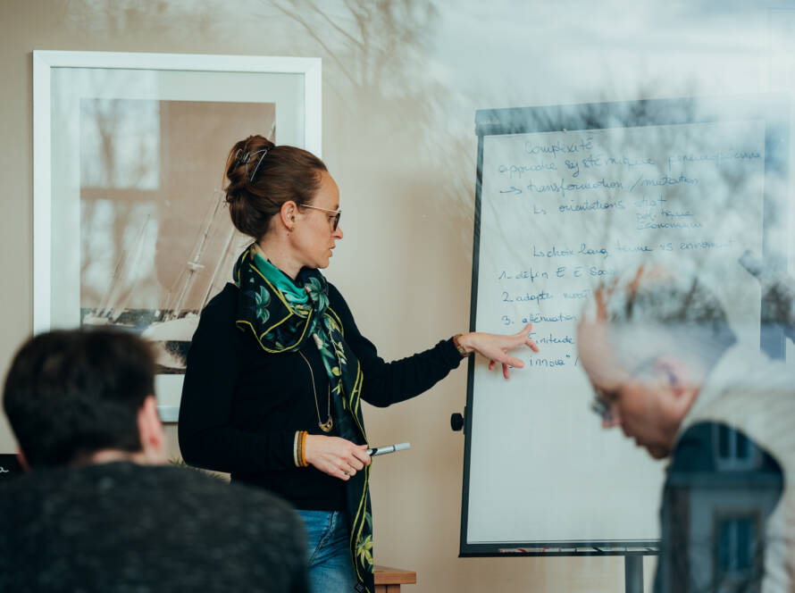 Anime un séminaire d’entreprise devant un paperboard, et feuille de route avec l’équipe. - Yélé Consulting